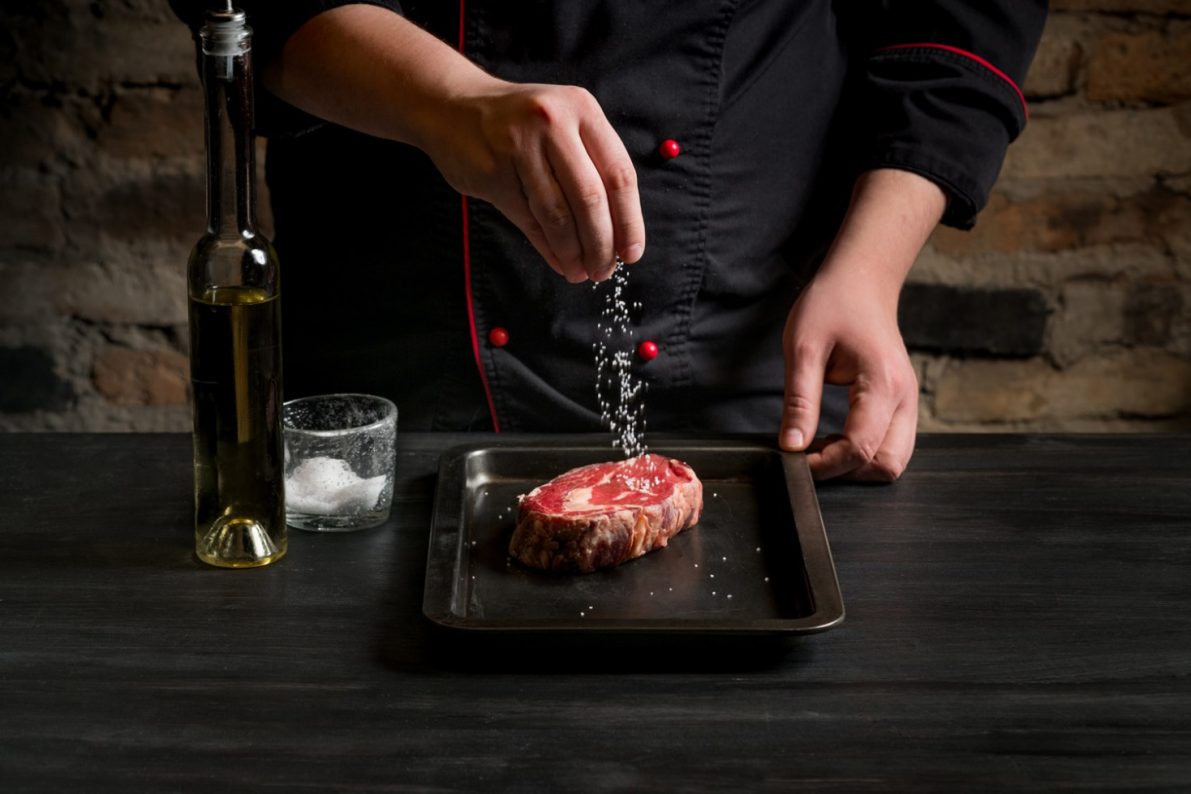 chef-salts-steak-grill-pan-preparing